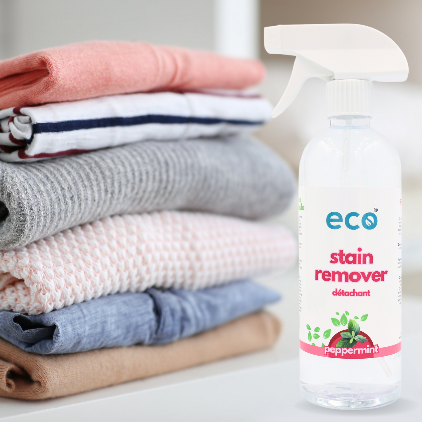 Clean clothes beside a bottle of Eco Refillery's stain remover.