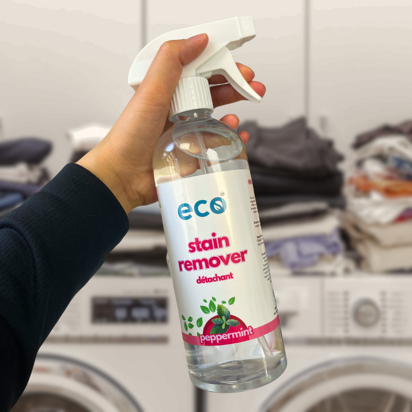 Person using Eco Refillery's stain remover, for a plant-based and eco-friendly laundry routine.